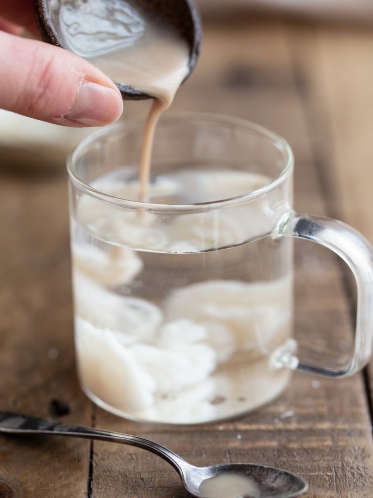 Pouring yeast mixture into lukewarm water.