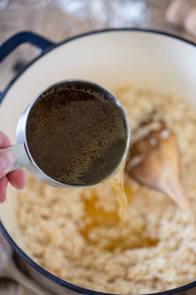 Adding stock to make risotto.
