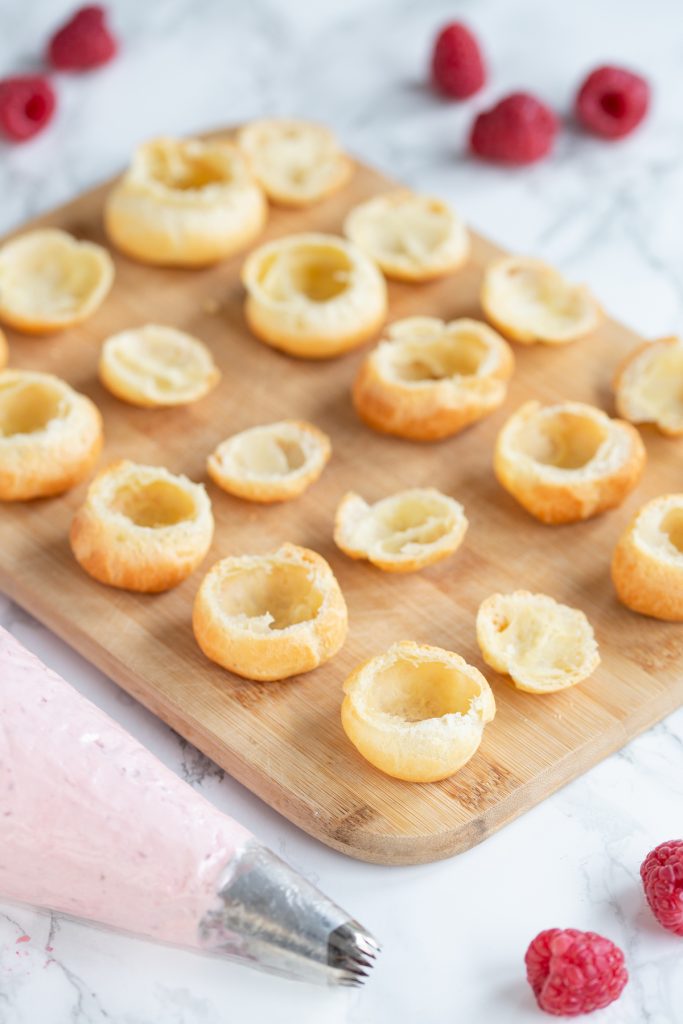 Choux pastry puffs with tops cut off exposing the hollow inside.