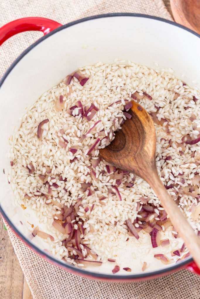 Red onion and rice in a Dutch oven.