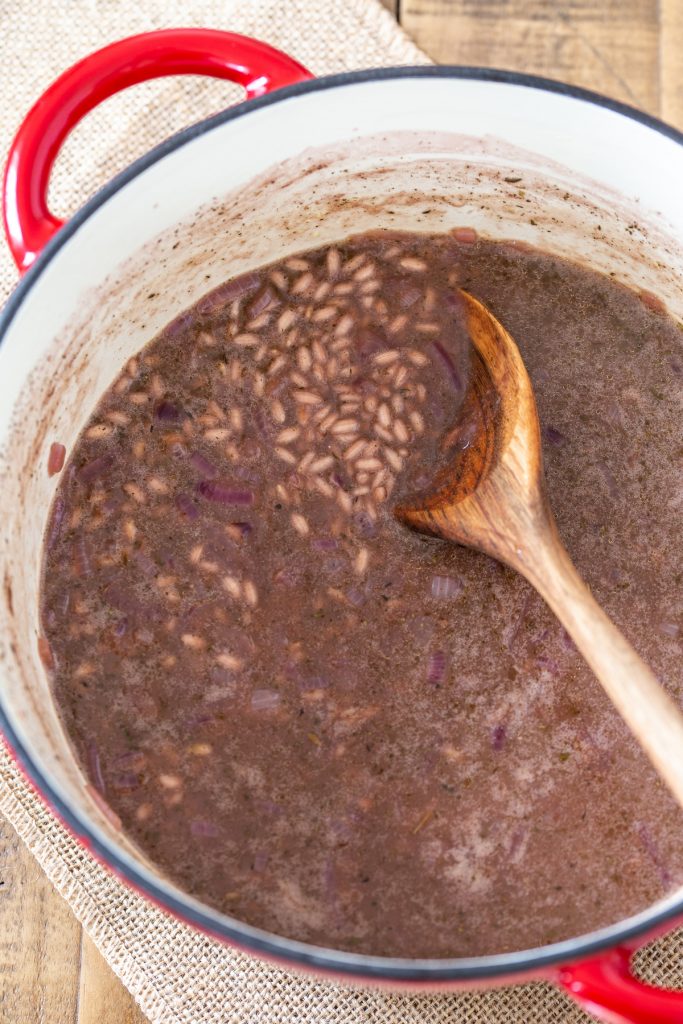 Adding stock to the risotto.