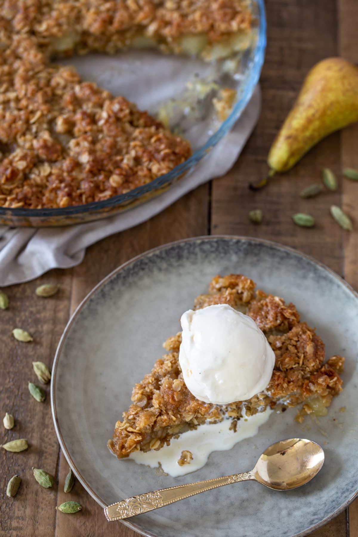 A slice of maple oat crisp with vanilla ice cream.