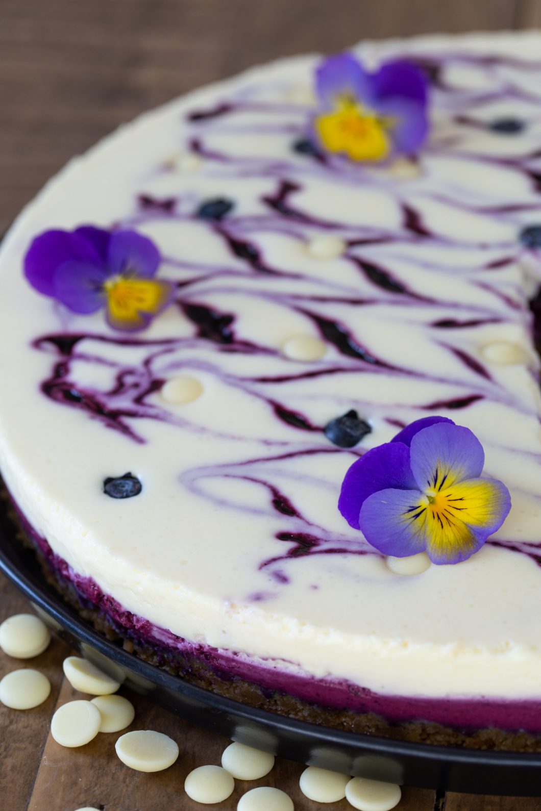 No-bake blueberry white chocolate cheesecake topped with pansies.