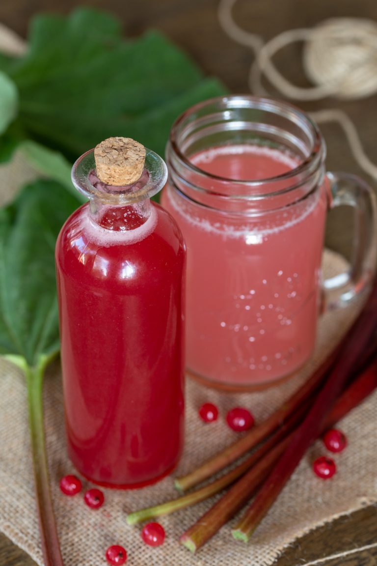 Rhubarb syrup in a bottle, diluted with water in a glass.