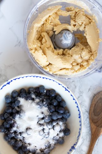 Blueberries and sugar in one bowl, the pastry in a food processor.