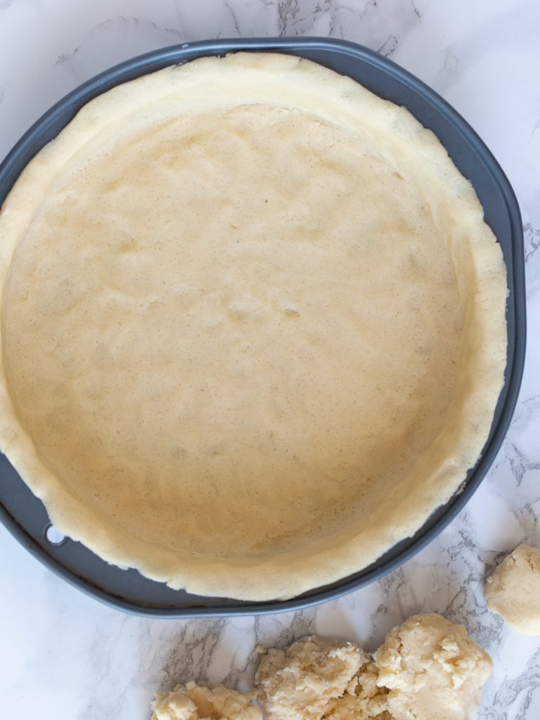 Pressing pastry into a cake pan.