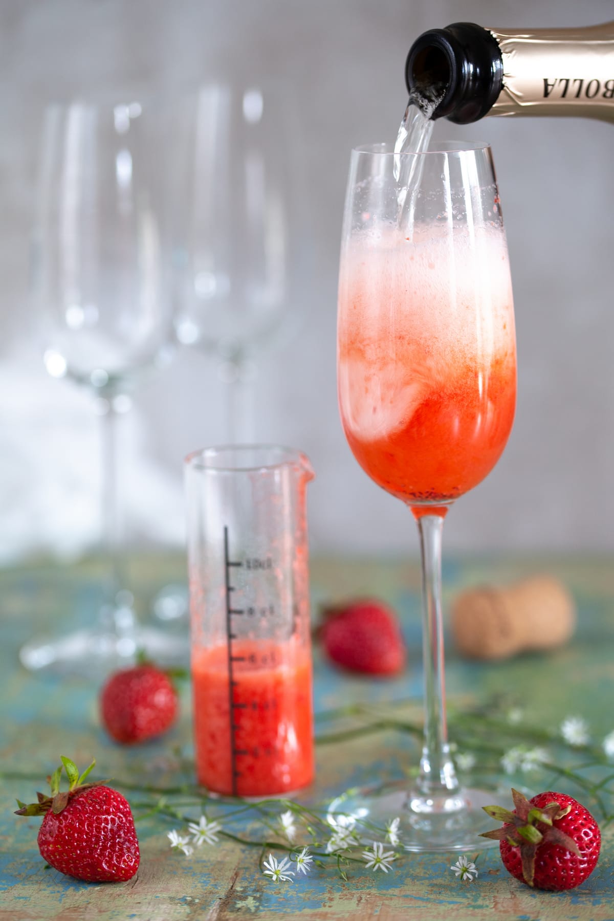 Prosecco and strawberry purée blending together.