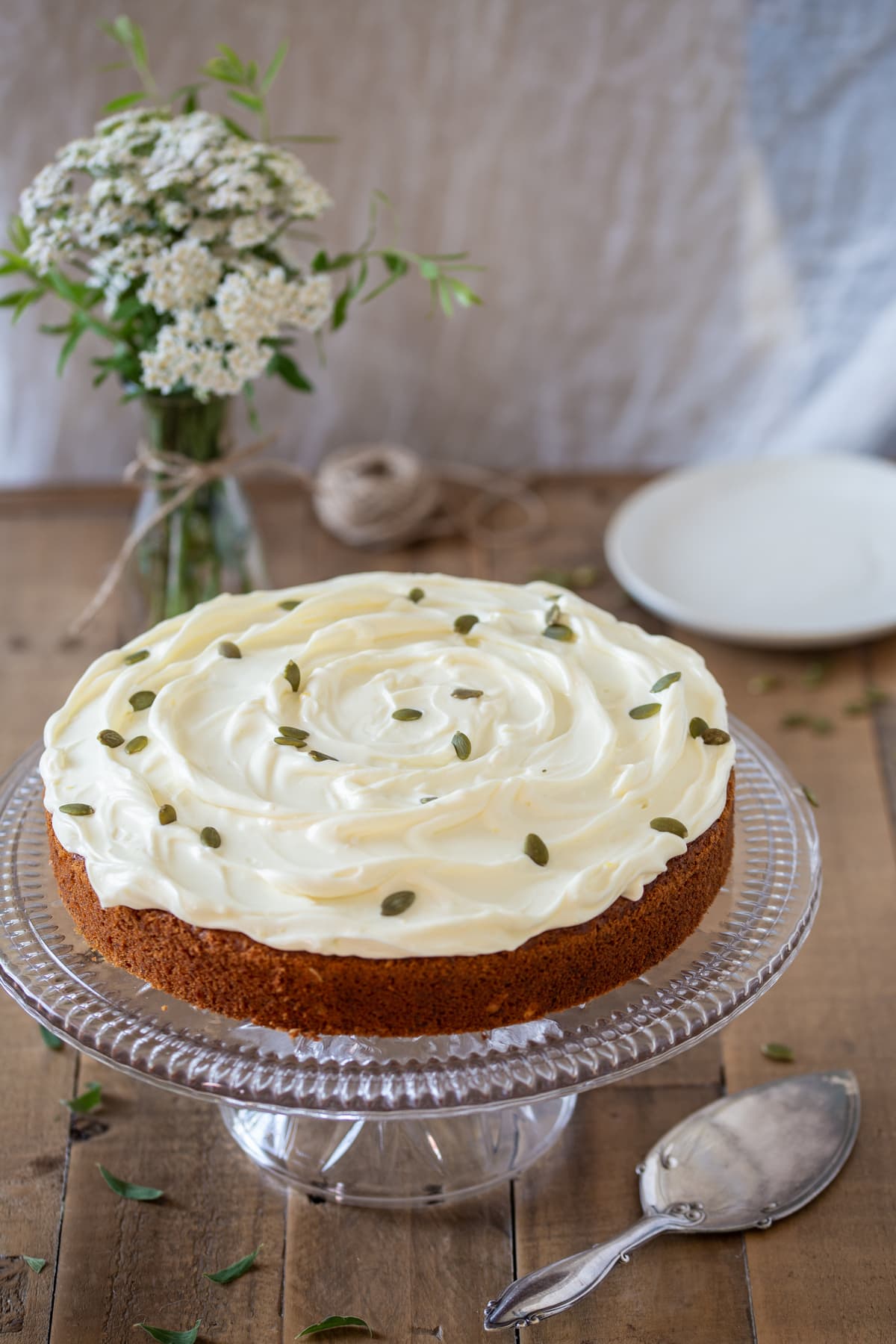 Carrot cake with pumpkin seeds over the frosting.