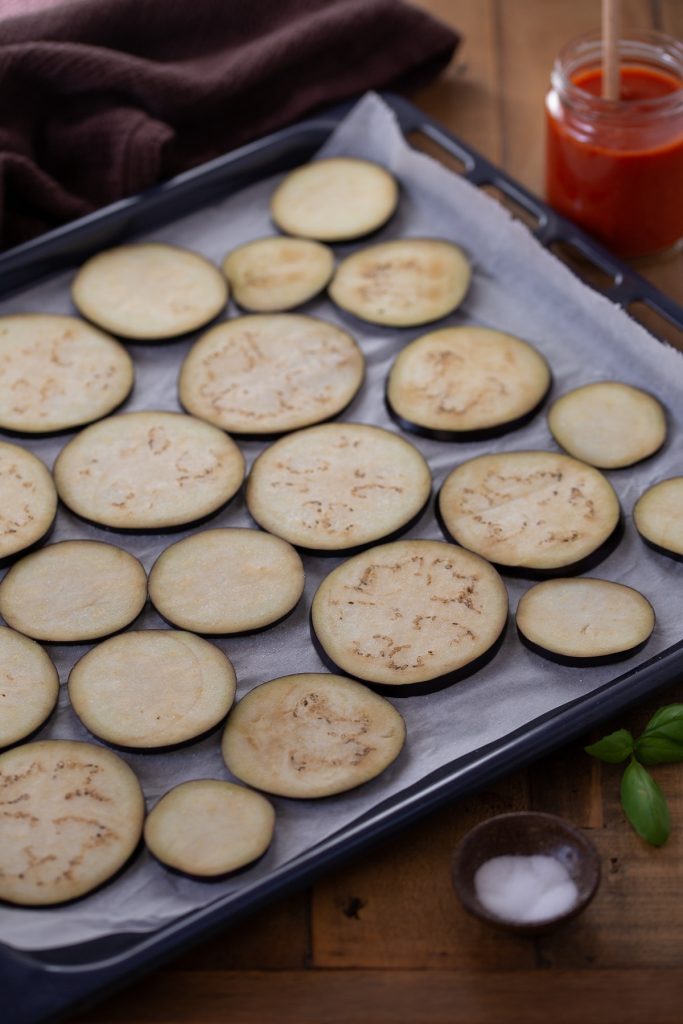 Eggplant sliced on an oven tray.