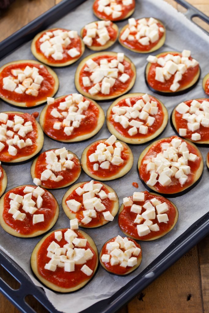Eggplant slices topped with tomato sauce and mozzarella.