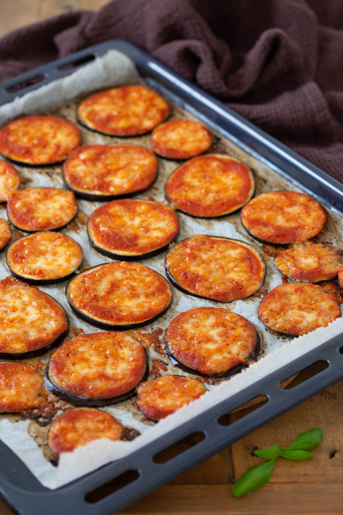 Baked eggplant pizza bites on an oven tray.