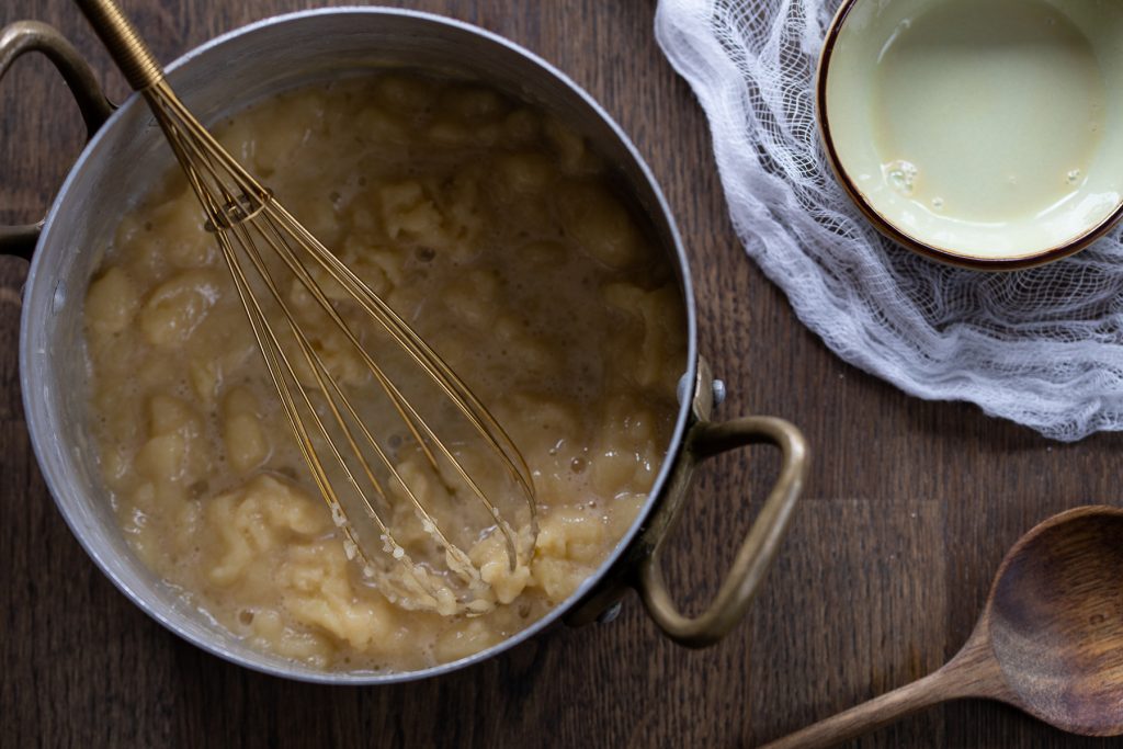 Adding egg to choux dough.