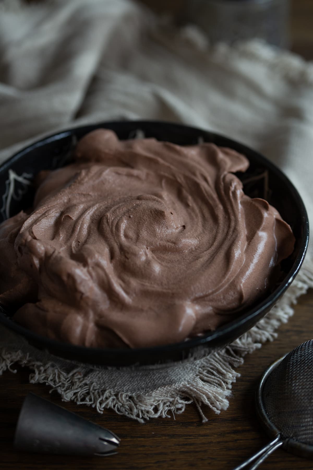 Bittersweet chocolate frosting with the top nicely twirled to show texture.