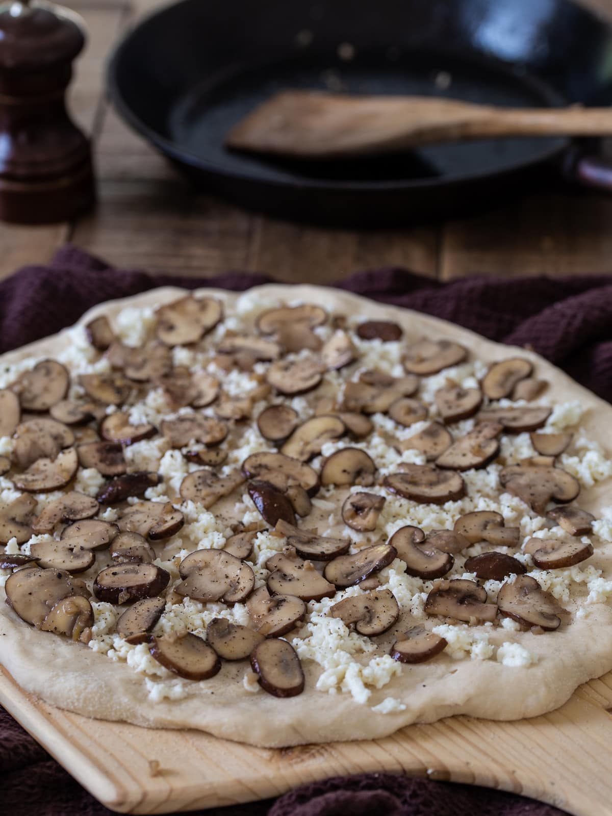 Pizza dough topped with mozzarella and sautéed mushrooms.