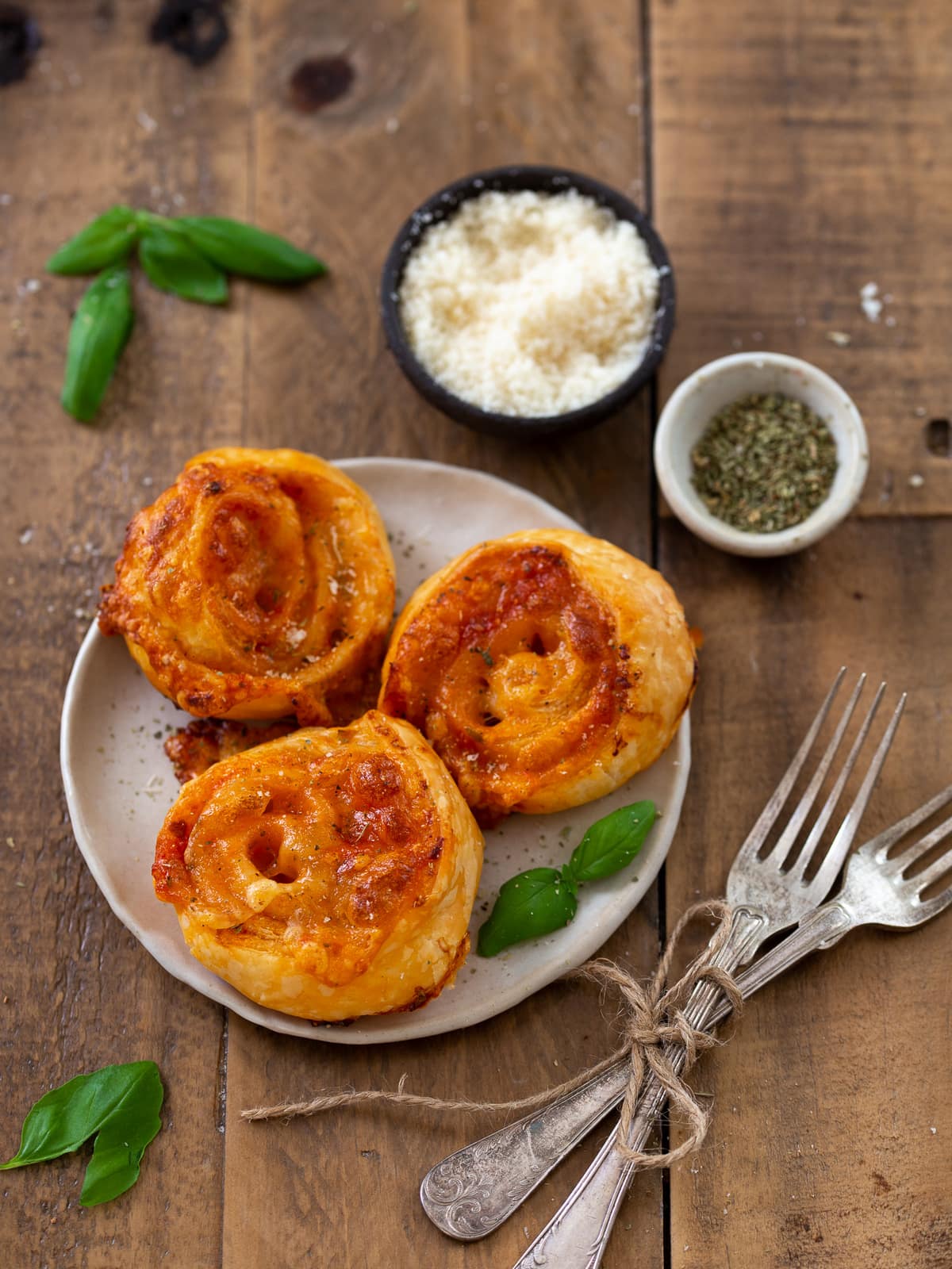 Three pizza pinwheels on a small plate.