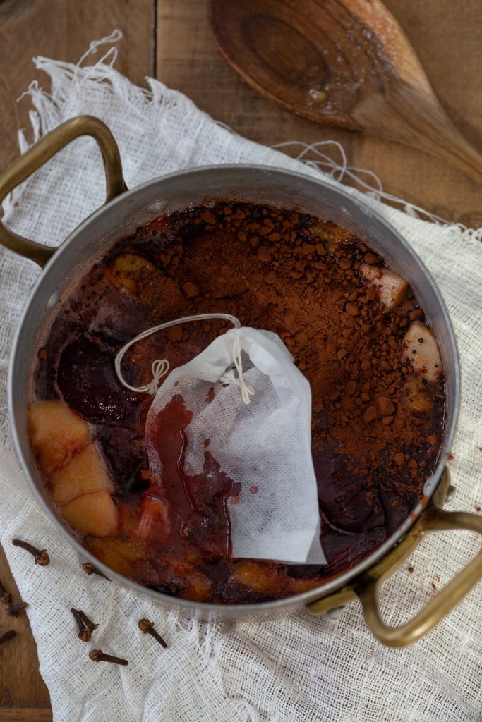 Adding cocoa and a teabag of cloves to the jam.