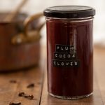 A plum clove cocoa jam in a labelled jar.
