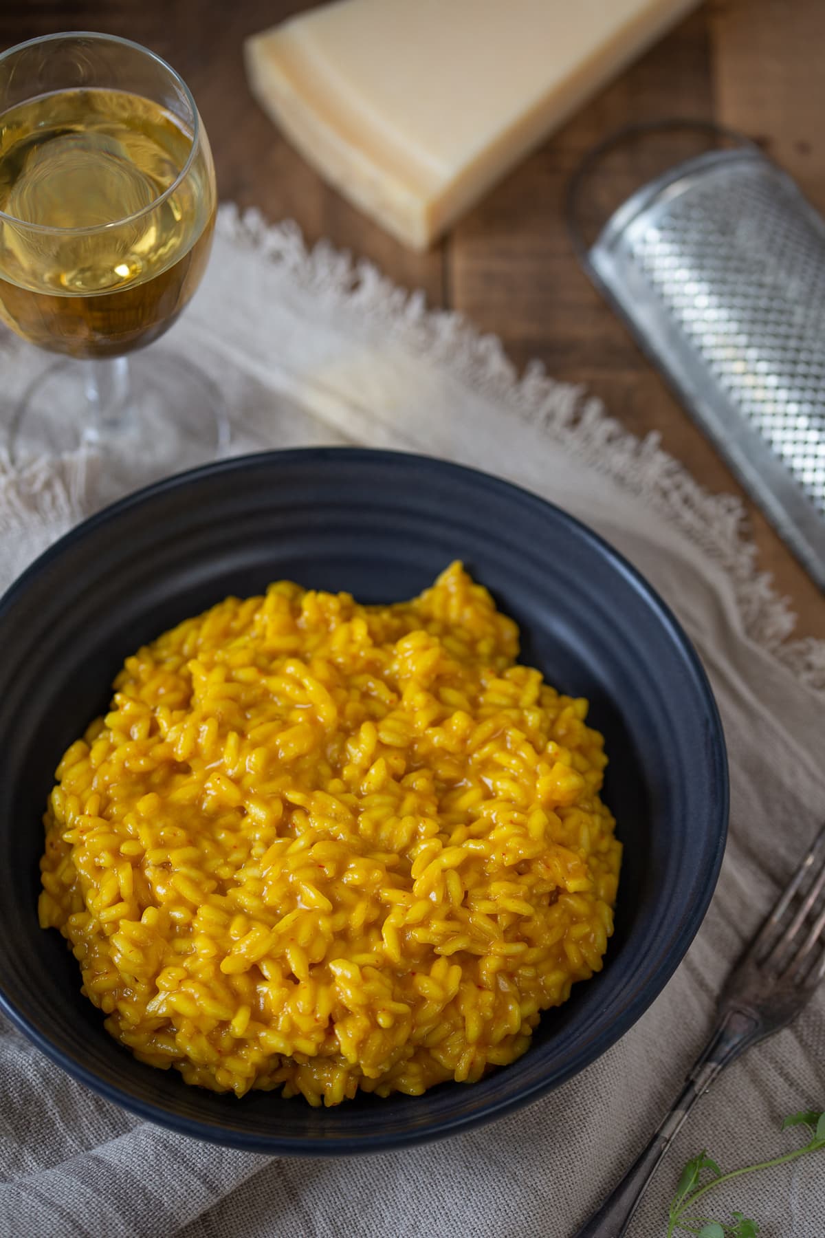 A portion of saffron risotto served in a blue bowl.