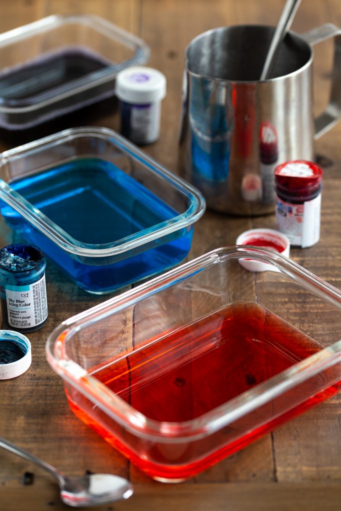 Preparing jello of various colours in different containers.
