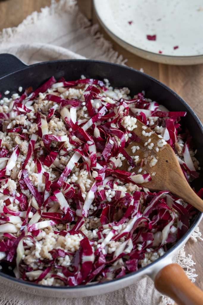 Adding sliced radicchio to the skillet.