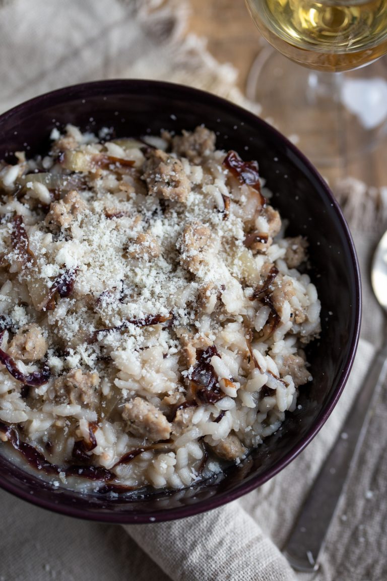 A portion of risotto in a dark purple bowl.