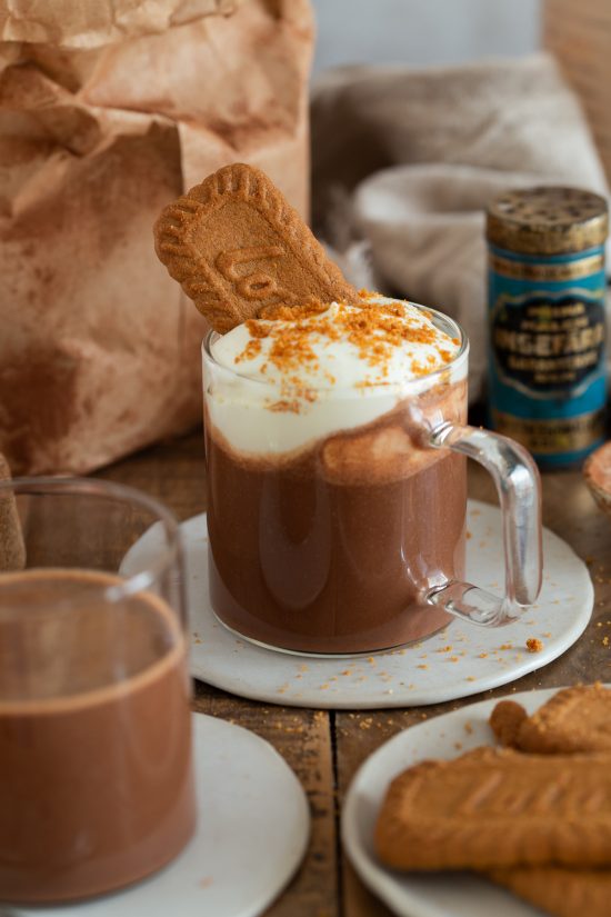 Biscoff hot chocolate topped with whipped cream and a cookie.