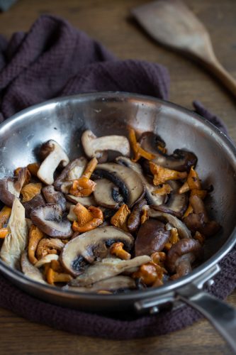 Mixed mushrooms sautÅed in butter in a skillet.