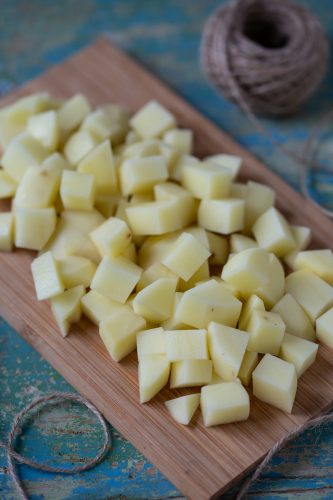Diced potatoes on a wooden cutting board.