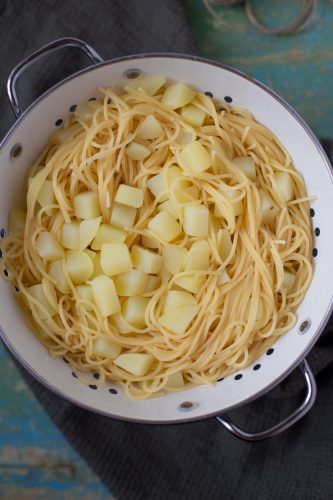 Cooked pasta and potatoes in a colander.