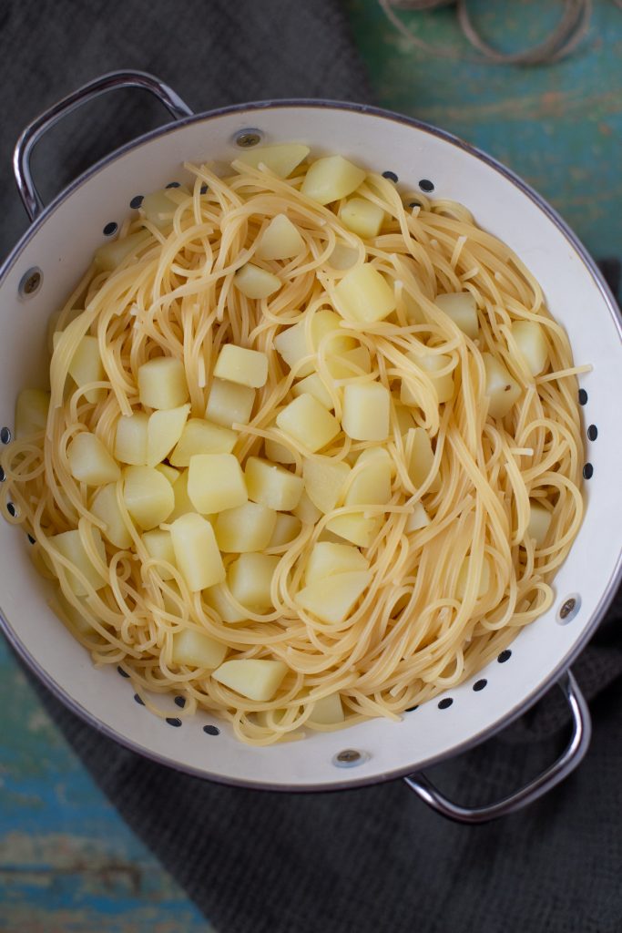 Cooked pasta and potatoes in a colander.