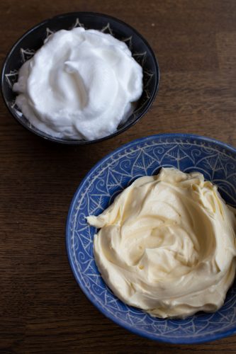 Whipped egg whites and mascarpone cream in 2 different bowls.