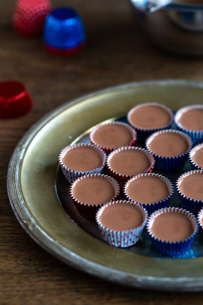 Chocolate and coconut oil mixture in tinfoil forms.