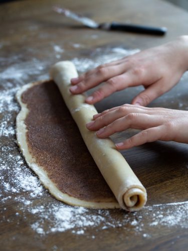 Hand rolling up the dough.