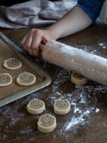 Lightly flattening the cookies with a rolling pin.