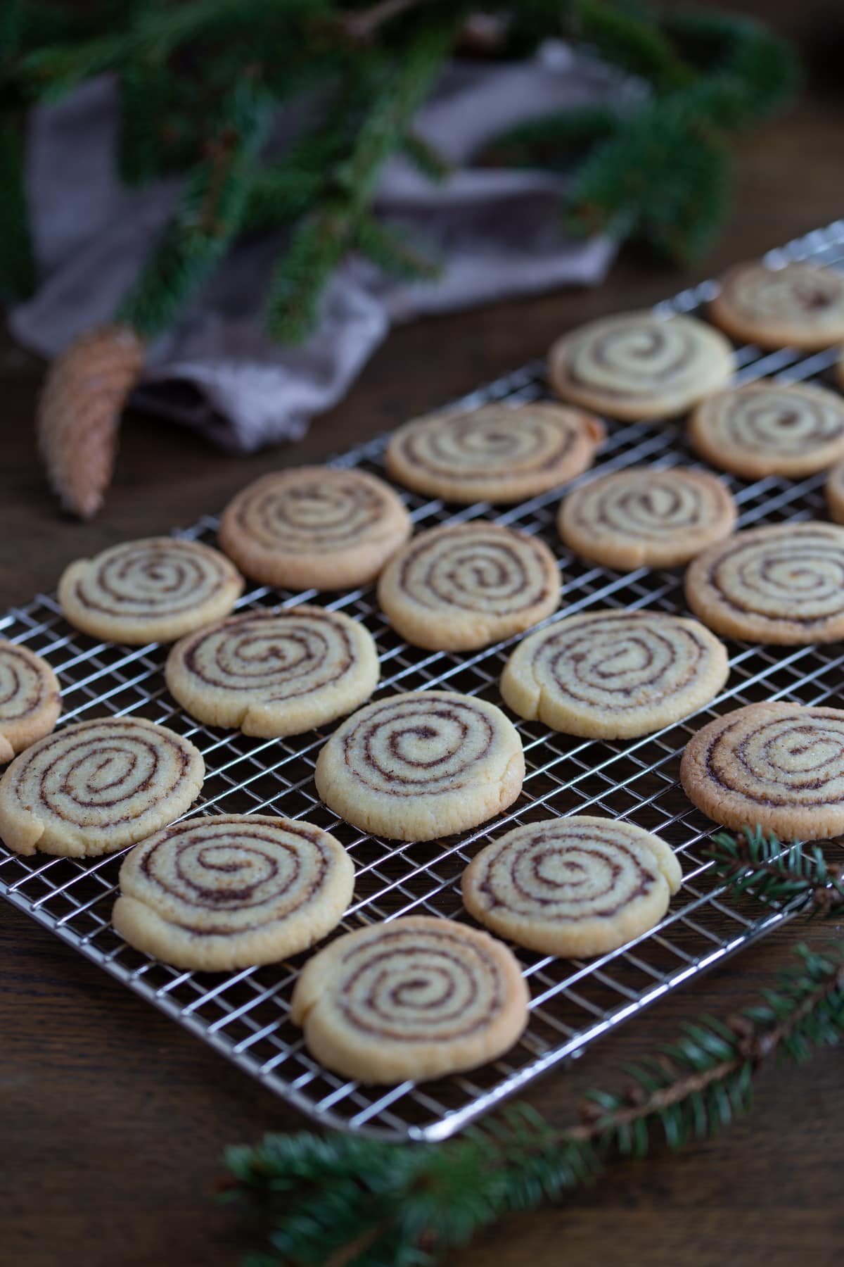Cinnamon roll cookies cooling on a rack.