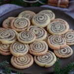 Kanelbulle cookies on a brown plate with pine decorations.