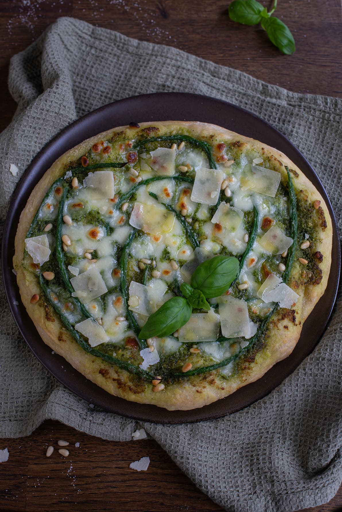 Pesto pizza with green beans seen from above.
