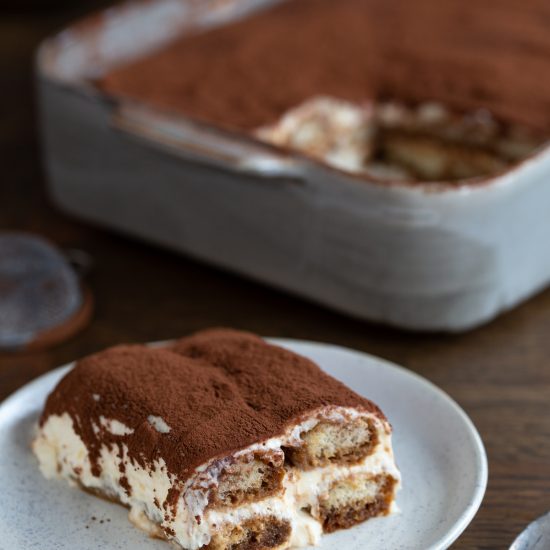 A serving of classic tiramisu on a white plate.