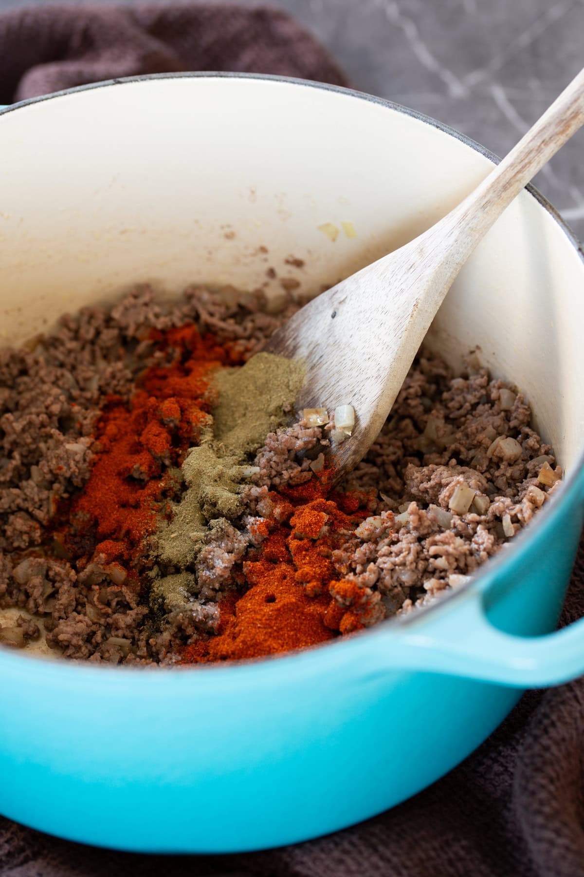 Adding hjerbs and spices to ground meat.