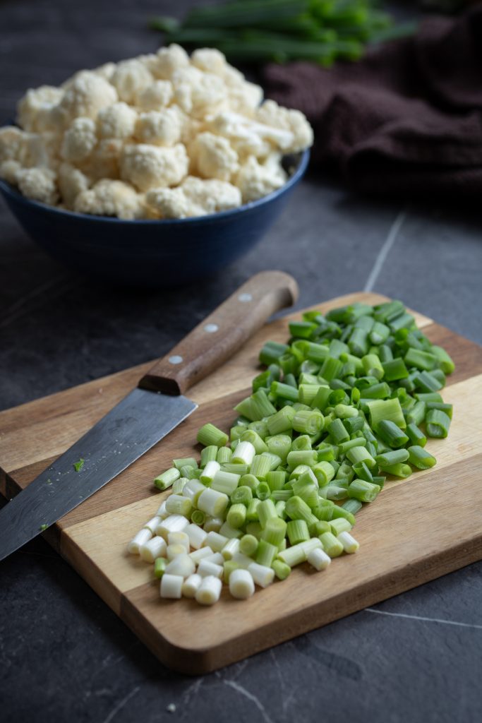 Chopped spring onion on a cutting board.