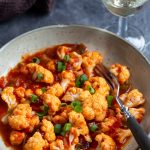 A portion of tomato pickled cauliflower on a serving plate.