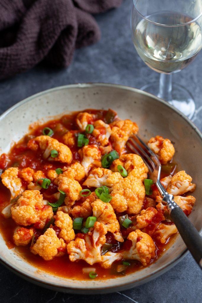 A portion of tomato pickled cauliflower on a serving plate.