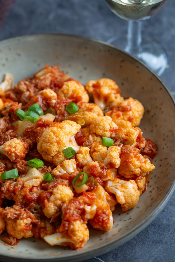 A portion of tomato pickled cauliflower on a serving plate.