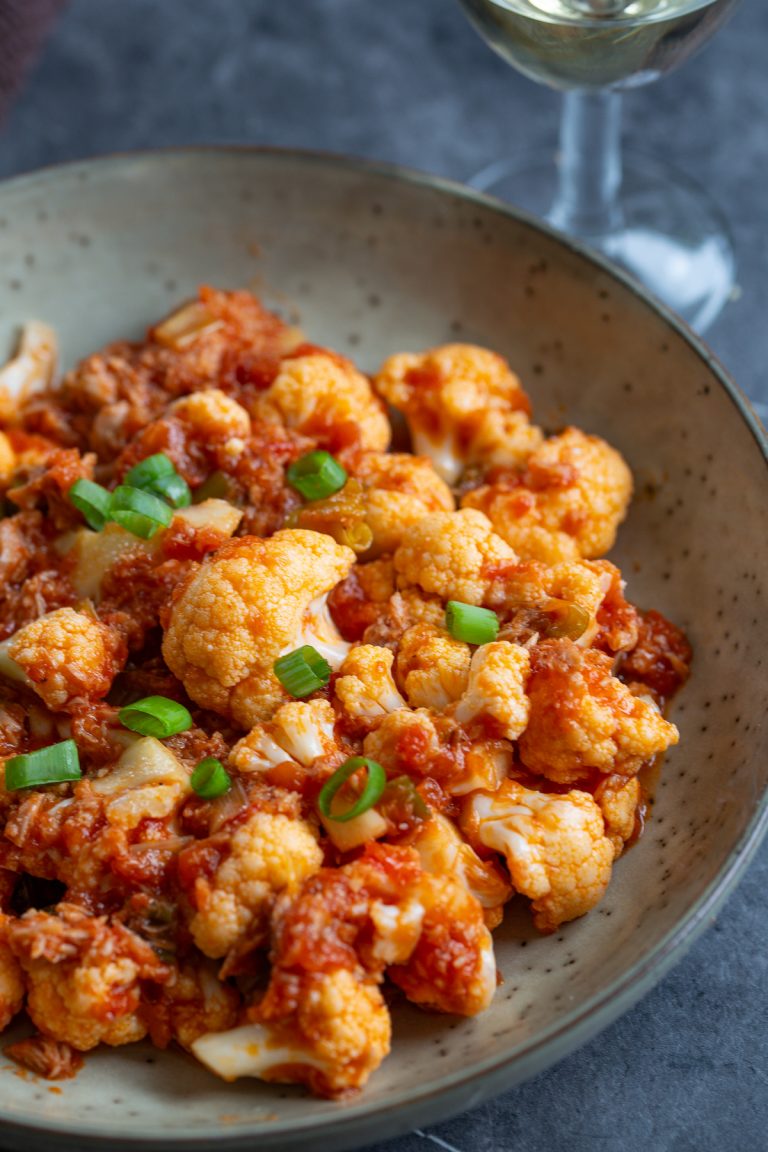 A portion of tomato pickled cauliflower on a serving plate.