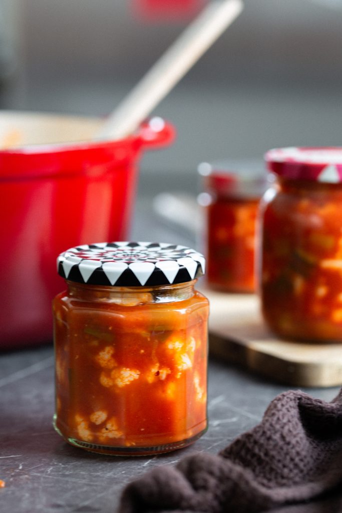 A preserving jar full of tomato pickled cauliflower
