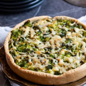 Broccoli and cheese pie on a brown plate.