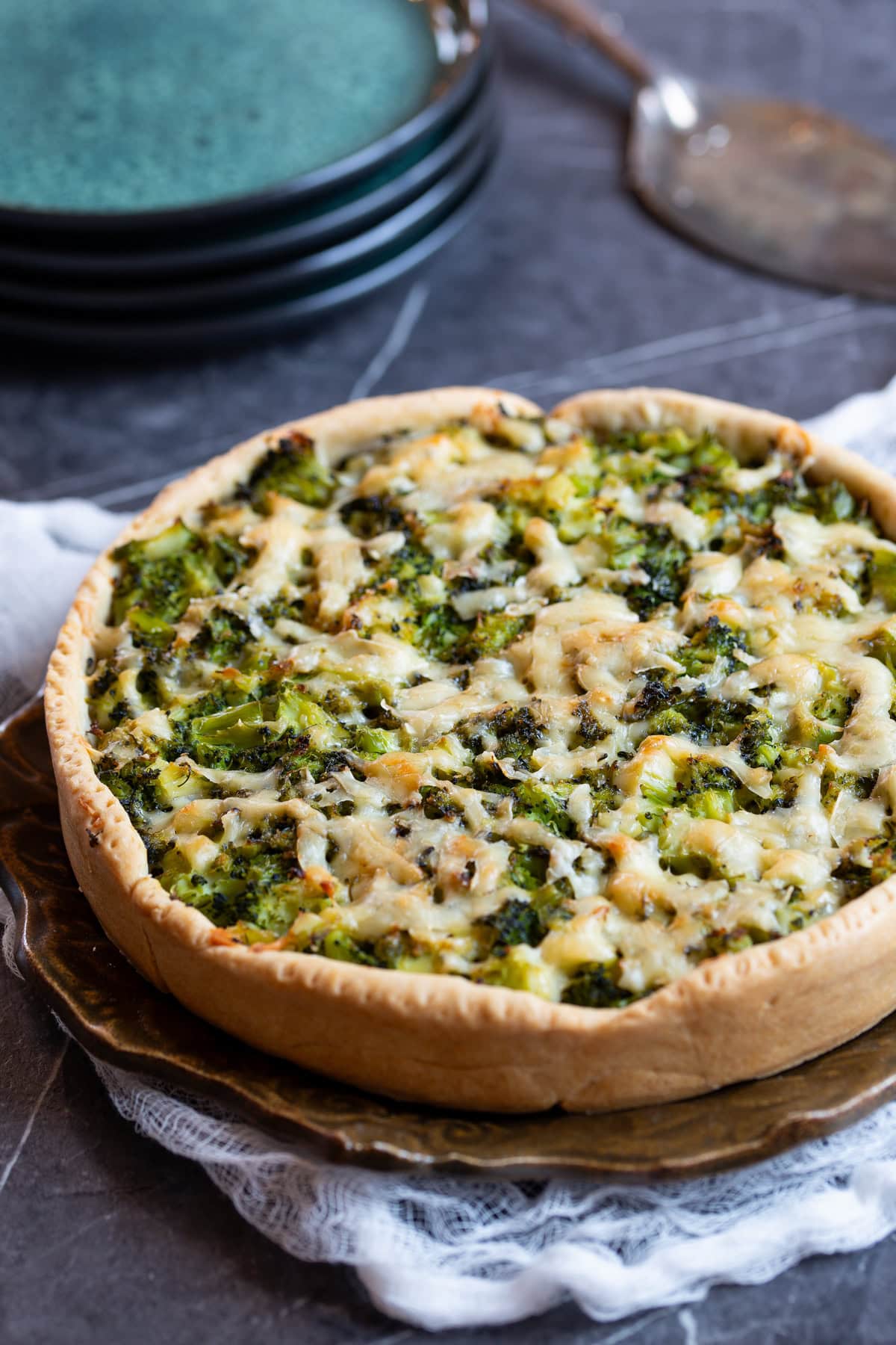 Broccoli and cheese pie on a brown plate.