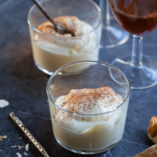 Mascarpone cream served with a dusting of cinnamon on top in clear bowls.