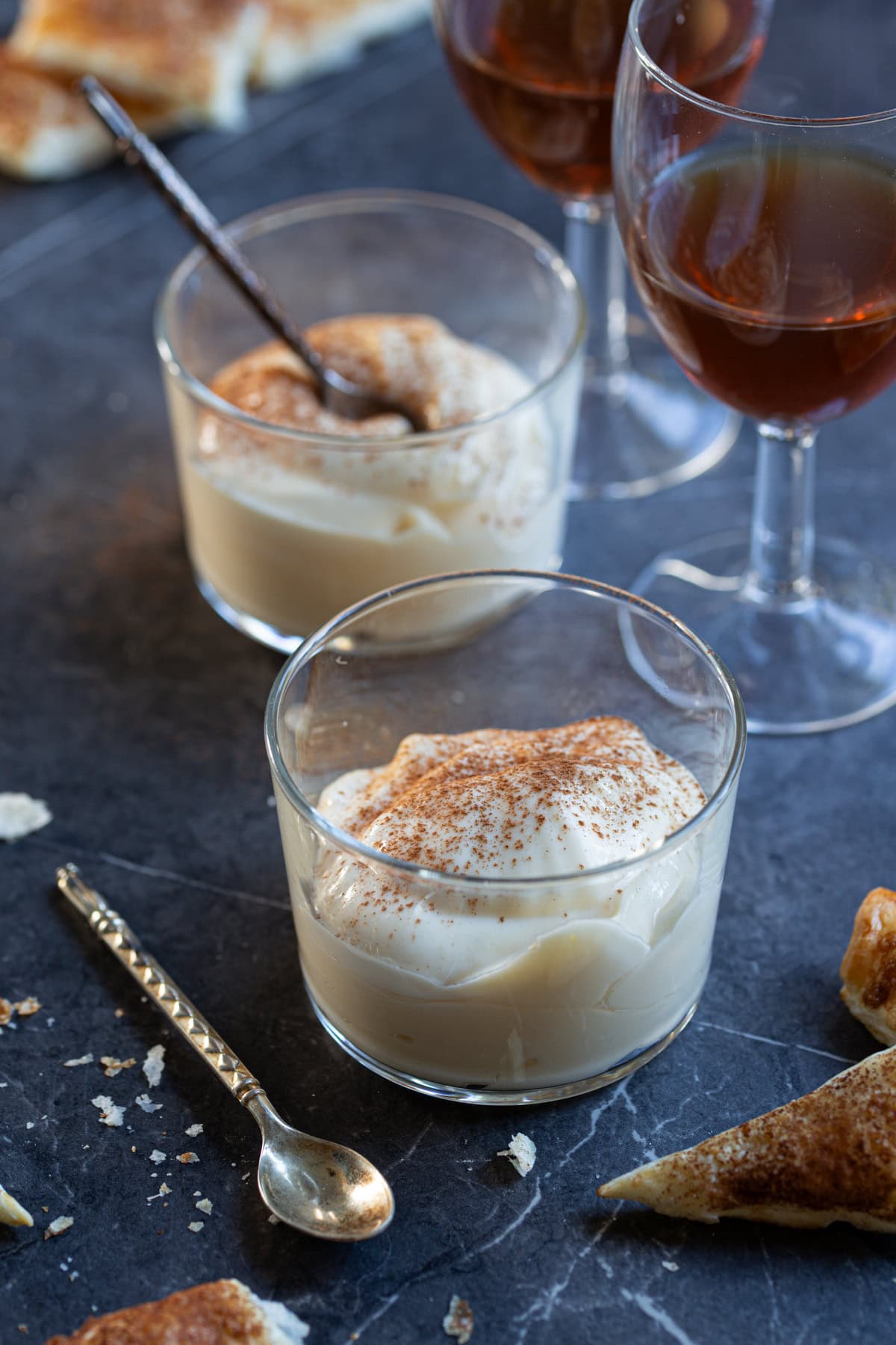 Mascarpone cream served with a dusting of cinnamon on top in clear bowls.