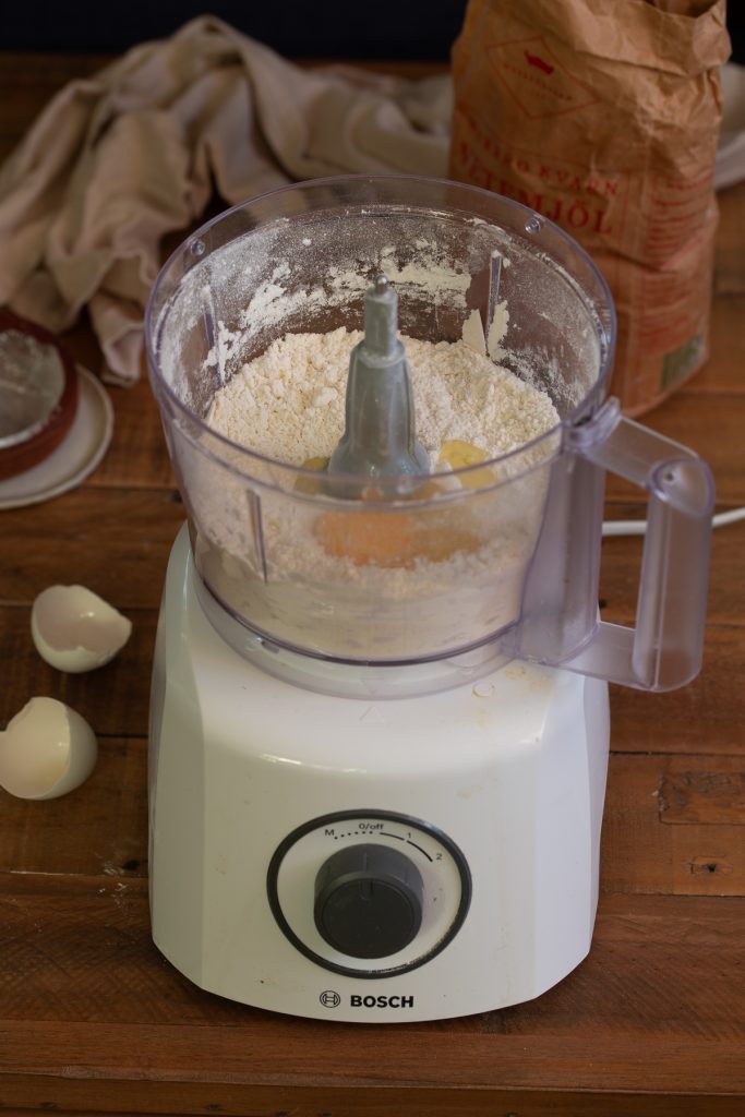 One egg added to dough mix in food processor.